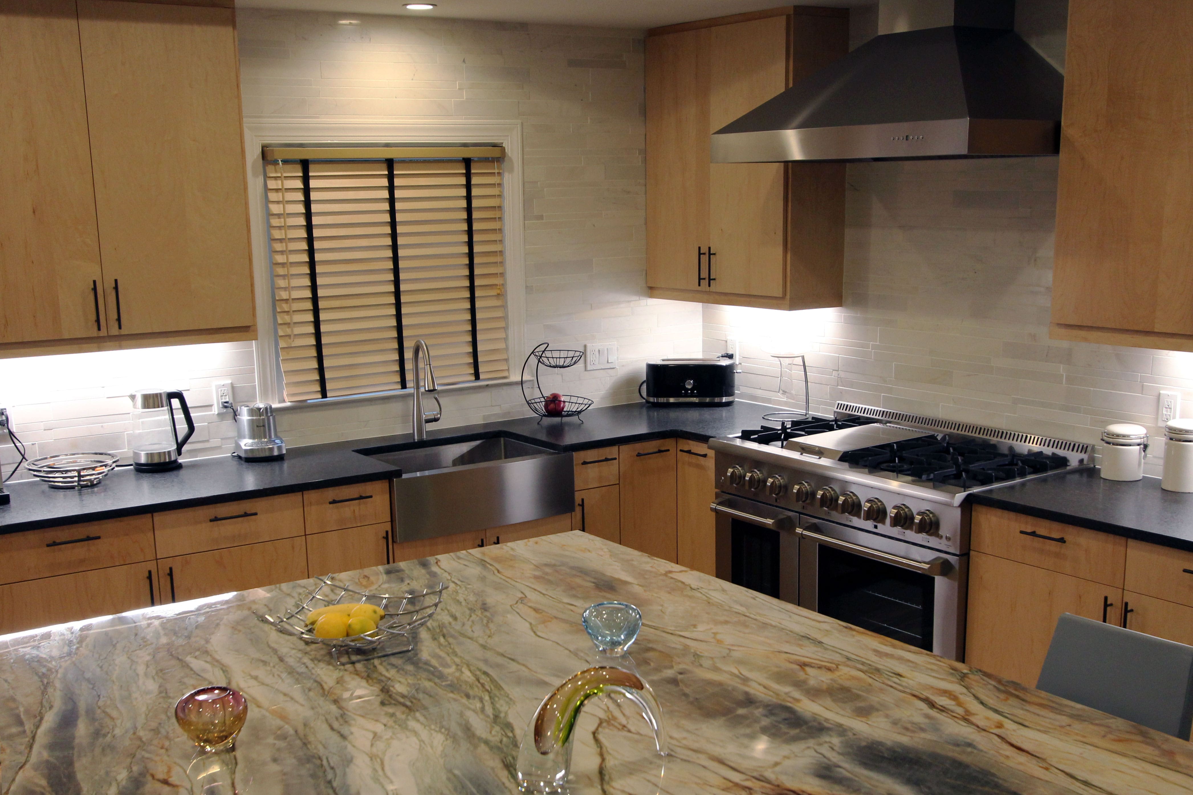 Norstone White Marble Lynia Interlocking Tiles used on a kitchen backsplash in a corner kitchen with large island and granite countertops